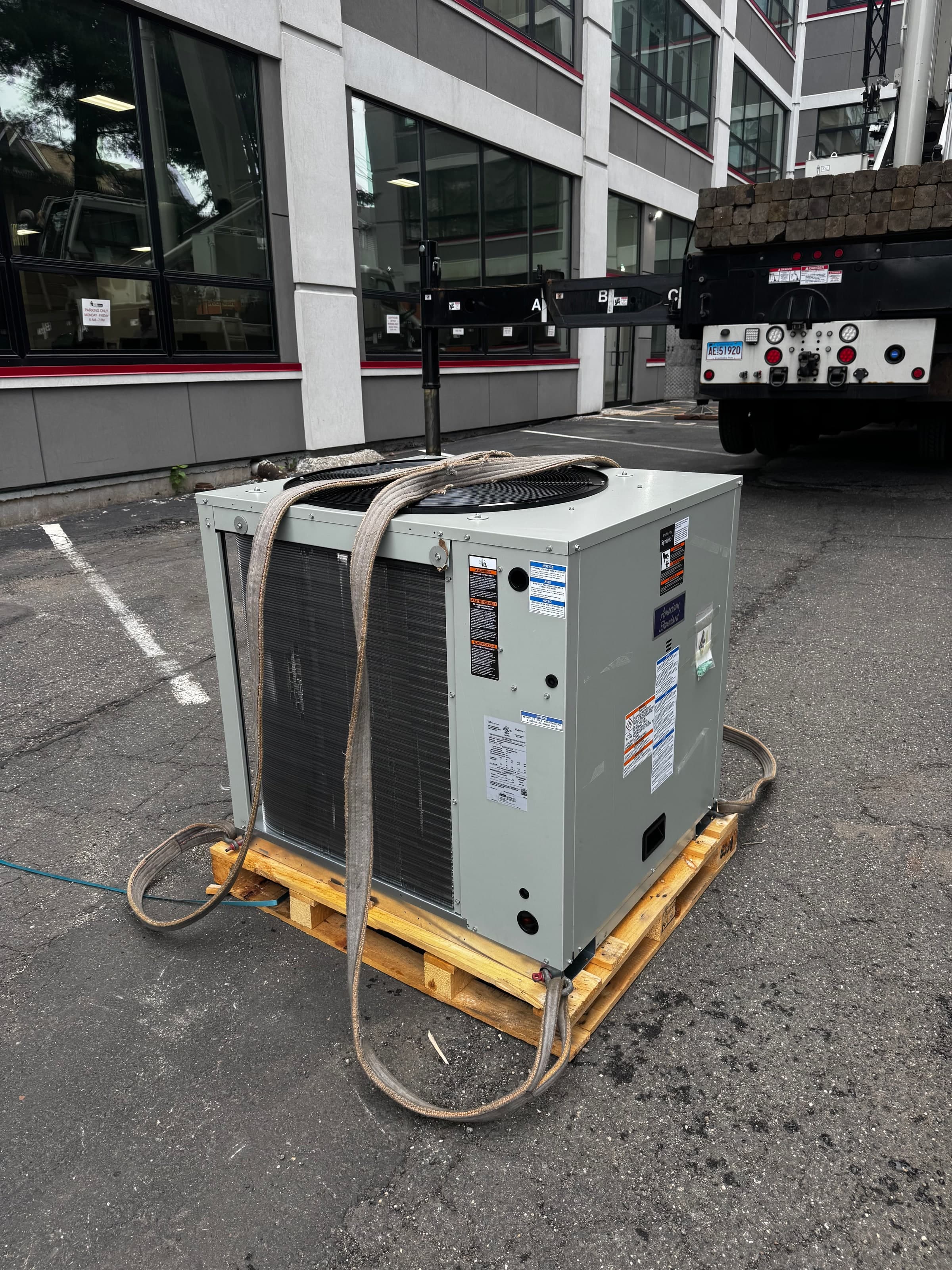 Commercial heat pump staged on a pallet before crane placement in Connecticut